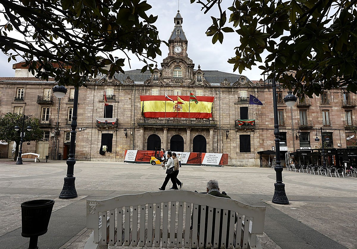 Vecinos caminan frente al Palacio municipal, en el Bulevar Demetrio Herrero de Torrelavega.