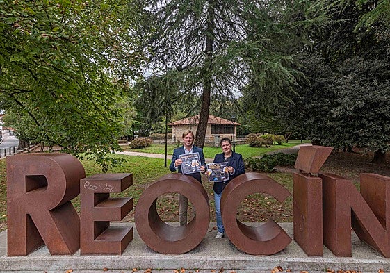 El alcalde de Reocín y la concejala de Festejos, con el cartel anunciador del festival.