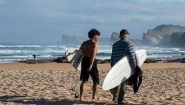 Tom Curren, a la derecha, se dirige al agua con su hijo Pat, en la playa de Liencres.
