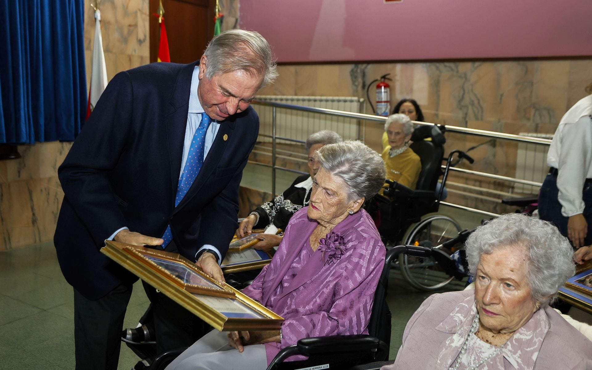Isaac Bolado entrega un obsequio a una de las residentes. 