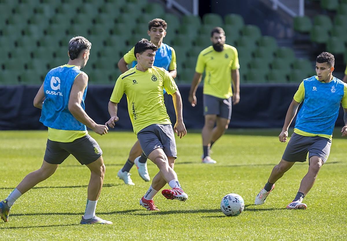 Aldasoro chuta el balón con Arana a su derecha, Puerta a su izquierda y Sergio Martínez a su espalda.