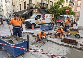 Varios empleados ejecutan los trabajos de renovación del pavimento en Daoiz y Velarde.