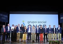 Galardonados y representantes institucionales, posan en una foto de familia, junto a miembros del grupo social Once