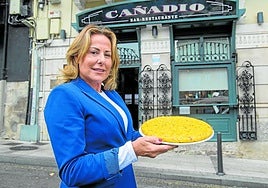 Teresa, ante la fachada de su restaurante, sostiene una tortilla recién hecha.