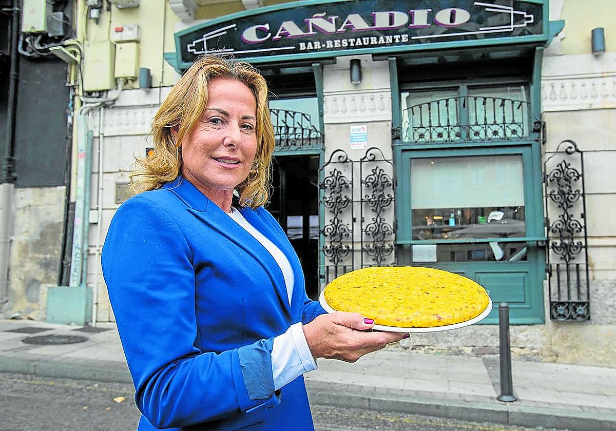Teresa, ante la fachada de su restaurante, sostiene una tortilla recién hecha.