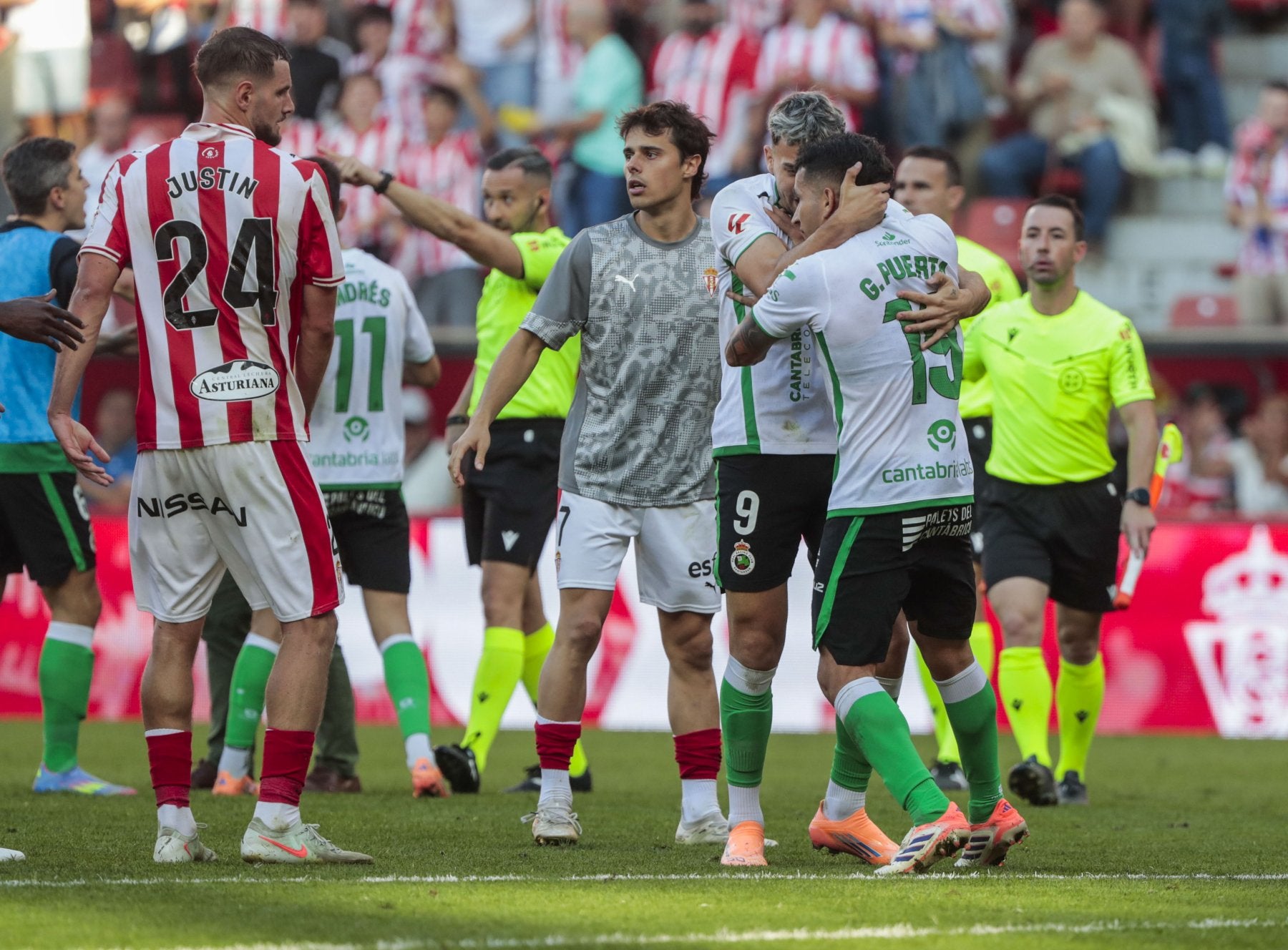 A la derecha de la imagen, Arana sujeta a Puerta durante las protestas al final del partido en Gijón.