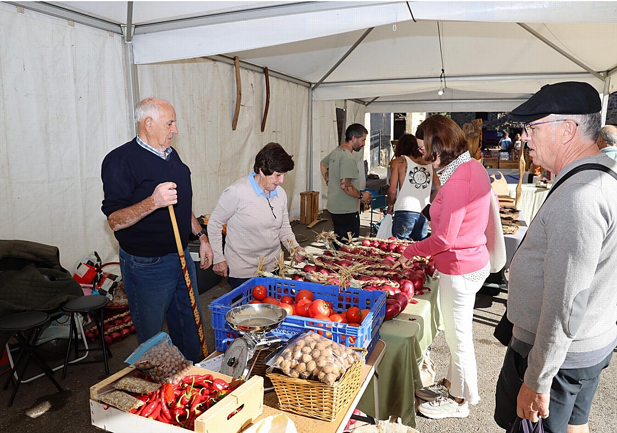 Imagen principal - Un puesto con productos de la huerta, las niñas del Aula de Cultura Tradicional del Valle de Camaleño, bailando junto al escenario, y una de las afortunadas con la cesta de productos de Liébana
