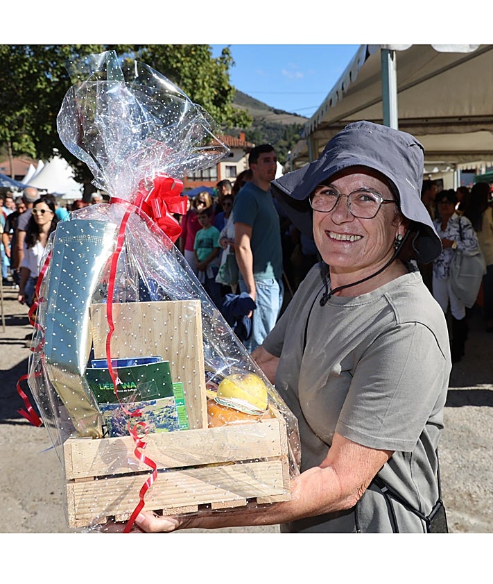 Imagen secundaria 2 - Un puesto con productos de la huerta, las niñas del Aula de Cultura Tradicional del Valle de Camaleño, bailando junto al escenario, y una de las afortunadas con la cesta de productos de Liébana