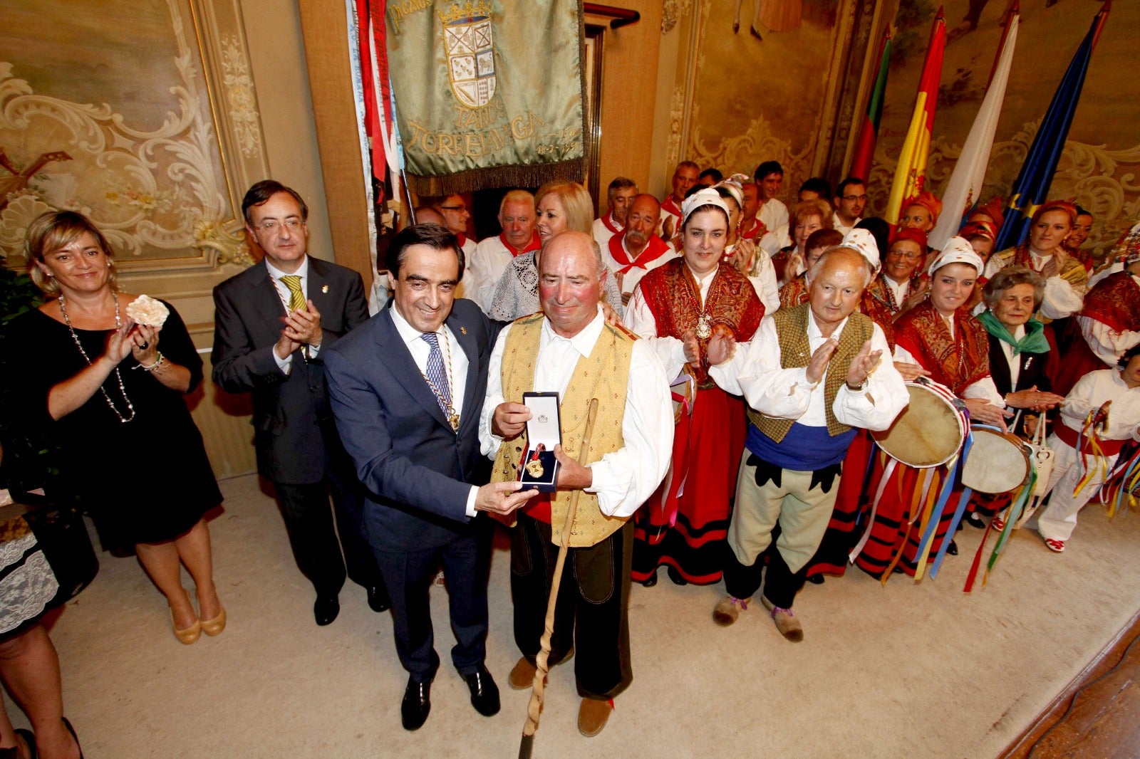 El exalcalde Ildefonso Calderón concede la Medalla de Oro de Torrelavega a la Agrupación de Danzas Virgen de las Nieves, presidida por Guerra, en el salón de Plenos del antiguo Ayuntamiento, en 2012.