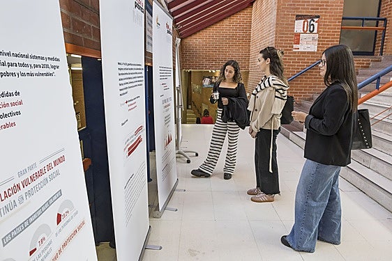Estudiantes de la UC contemplan la exposición 'Fin de la pobreza' situada en el Interfacultativo