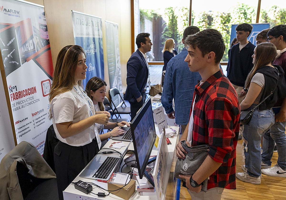 Uno de los jóvenes asistentes se acerca a dejar su solicitud en uno de los estands de las empresas.