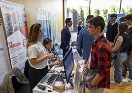 Uno de los jóvenes asistentes se acerca a dejar su solicitud en uno de los estands de las empresas.