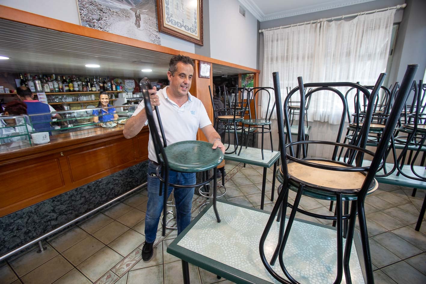 Lorenzo Ibáñez recoge las sillas en el bar Puchi.