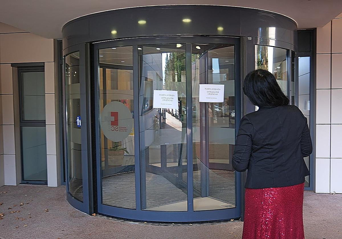 Una vecina se dirige a la puerta giratoria estropeada.