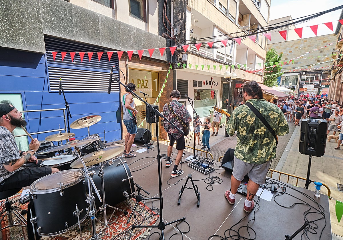 Una banda toca sobre un escenario montado en mitad de la calle, este verano, durante las fiestas de Torrelavega.