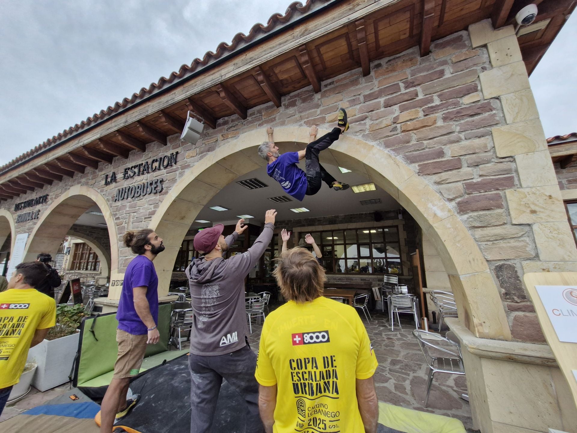 Varios escaladores, pendiente del que realiza el esfuerzo y sujetar en caso de caída.