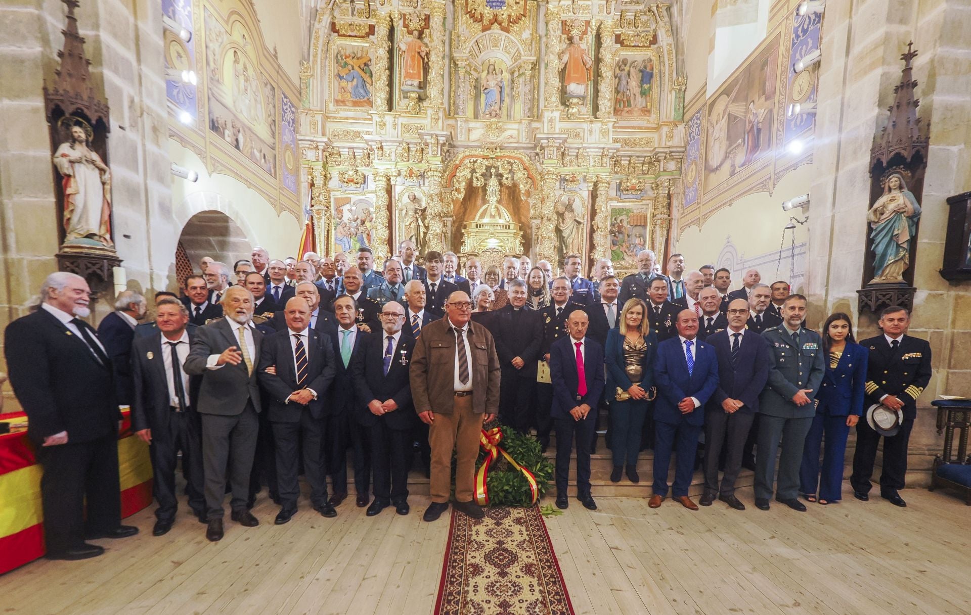 Imagen de familia de los condecorados, mientras de la asociación y asistentes al acto