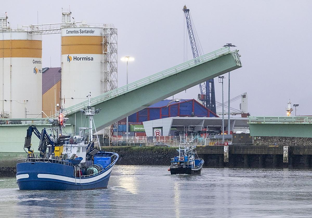 Dos embarcaciones pesqueras pasan bajo el puente levadizo de Raos.