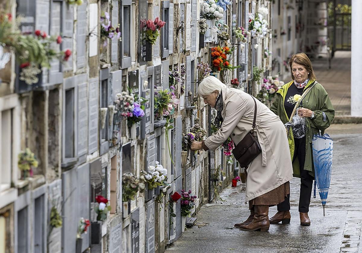 Dos mujeres ponen flores en un nicho de Ciriego este sábado.