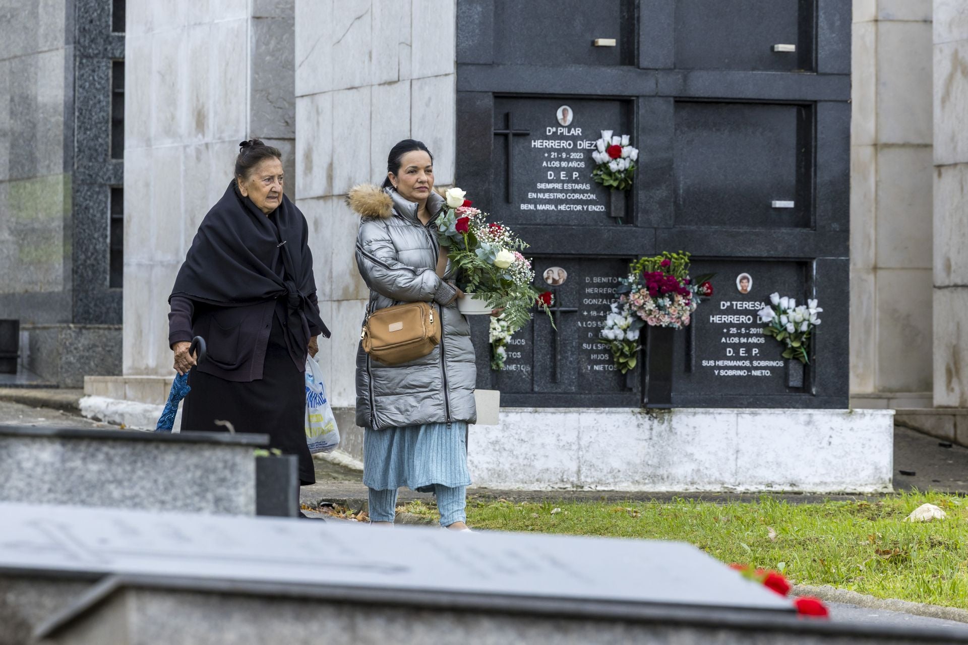 Dos mujeres, con un gran ramo de flores.