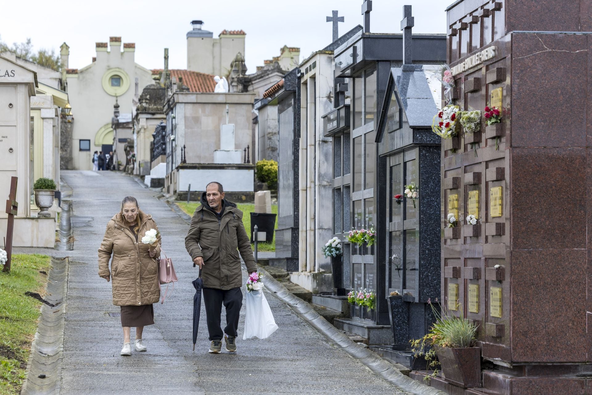 Abrigos y paraguas en un día de Todos los Santos que, a primera hora, vino con agua. 