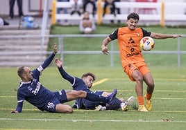 Abad, del Sámano, trata de controlar el balón mientras dos rivales del Marino de Luanco intentan frenarlo