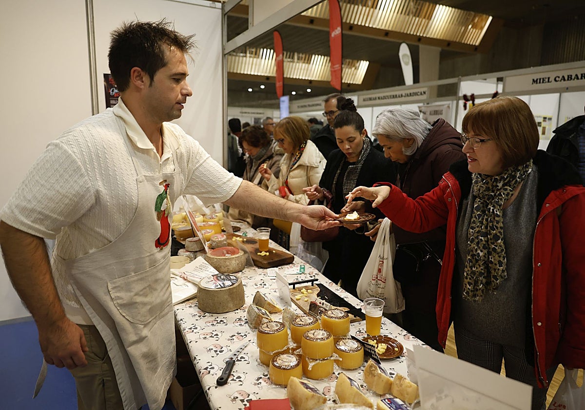 Una clienta prueba un queso en una feria agroalimentaria.