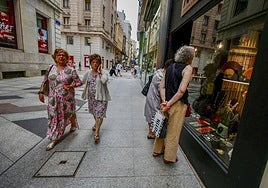 Clientes observan un escaparate de Santander.