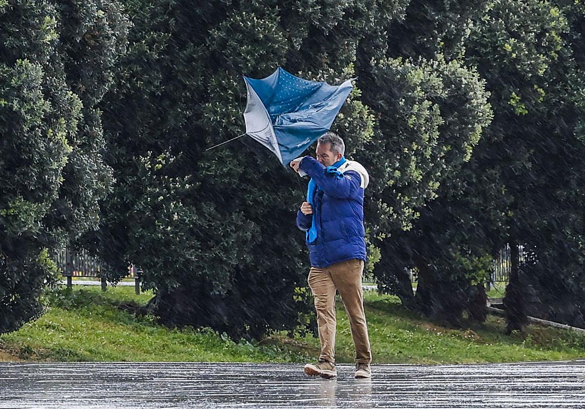 Un hombre en plena faena contra el viento.