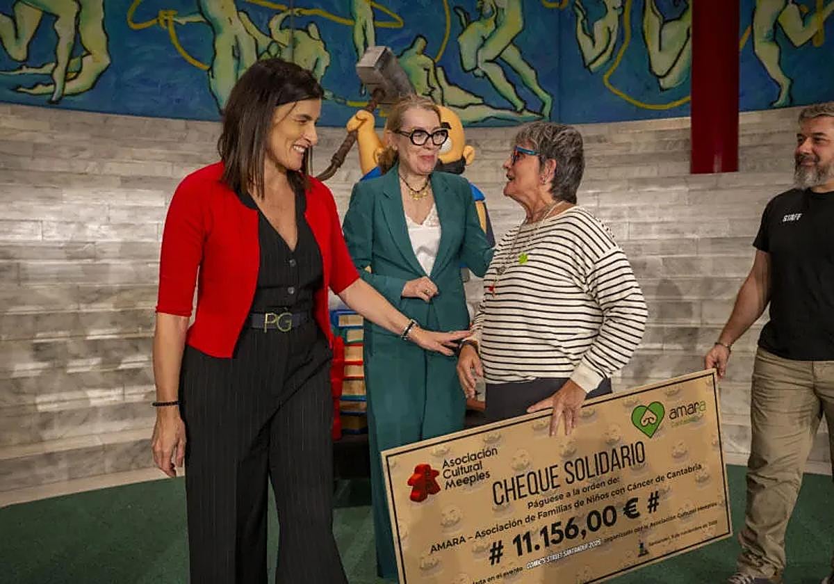 Gema Igual y Eva Guillermina Ferrnández acompañan a los representantes de la Asociación Cultural Meeples y de AMARA Cantabria durante la entrega del cheque solidario de 11.156 euros recaudados en el festival 'Comic's Street'.