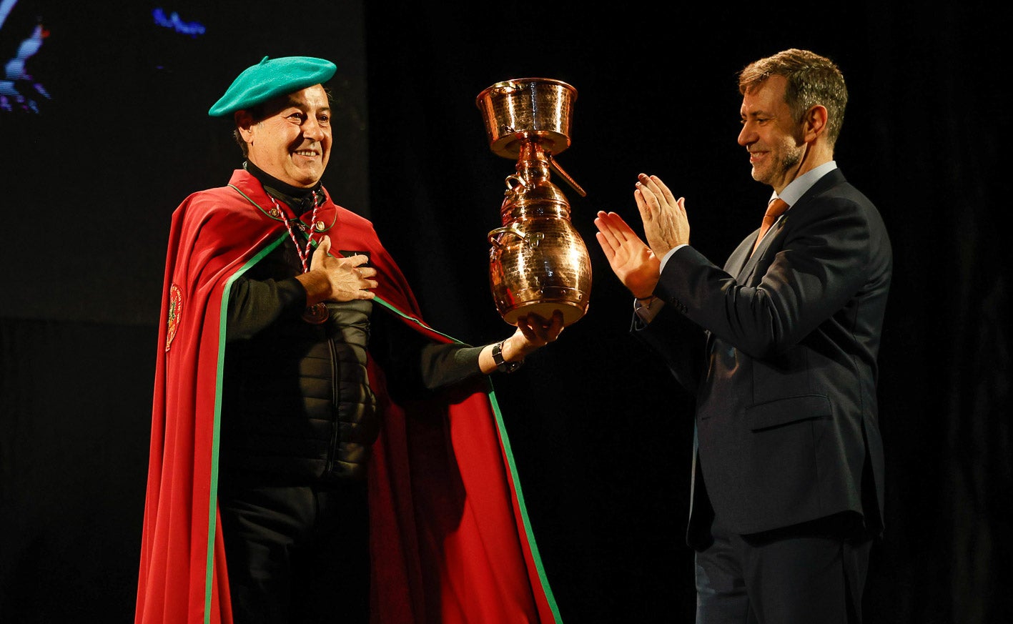 El consero de Turismo entrega al periodista una alquitara de regalo.