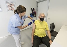 Una enfermera administra la vacuna de la gripe a un hombre en el centro de salud de Bezana.