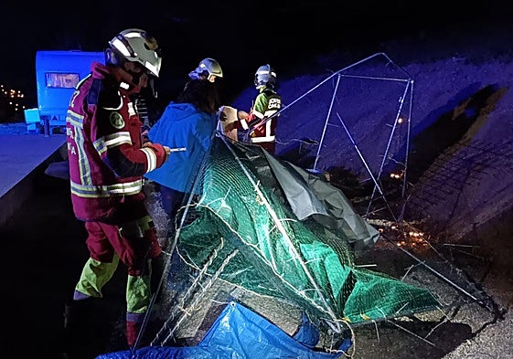 Los bomberos del Gobierno de Cantabria retiran un invernadero tirado por el viento en Penilla (Villafufre).