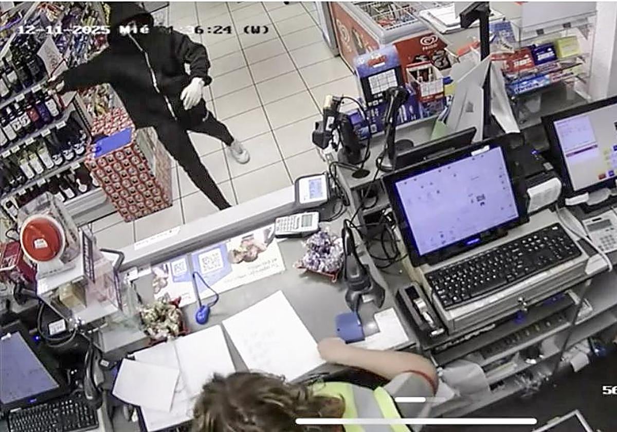 Uno de los asaltantes amenaza con una pistola a la trabajadora de la gasolinera de Torres (Torrelavega), en imágenes captadas por la cámara de seguridad.