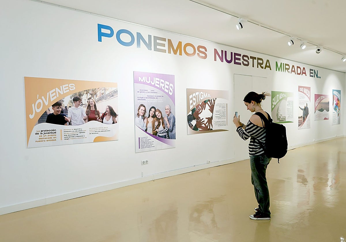 Una joven inmortaliza uno de los carteles de la exposición.