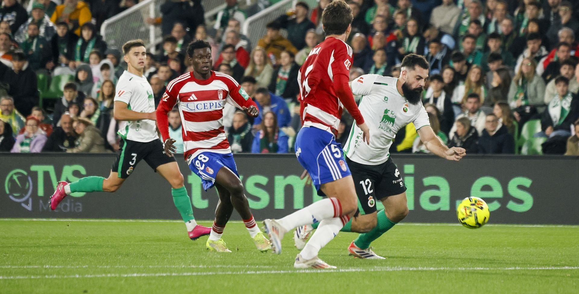 Villalibre conduce el balón y Lama y Oscar, del Granada buscan frenarlo
