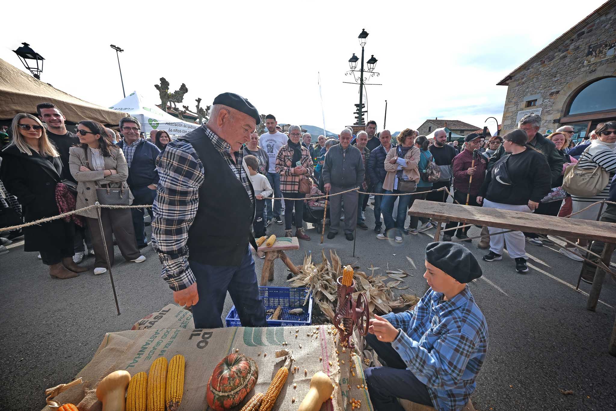 Un niño aprende a pelar la mazorca de maíz.