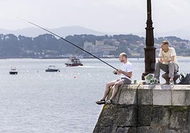 Un pescador lanza la caña en la bahía de Santander.