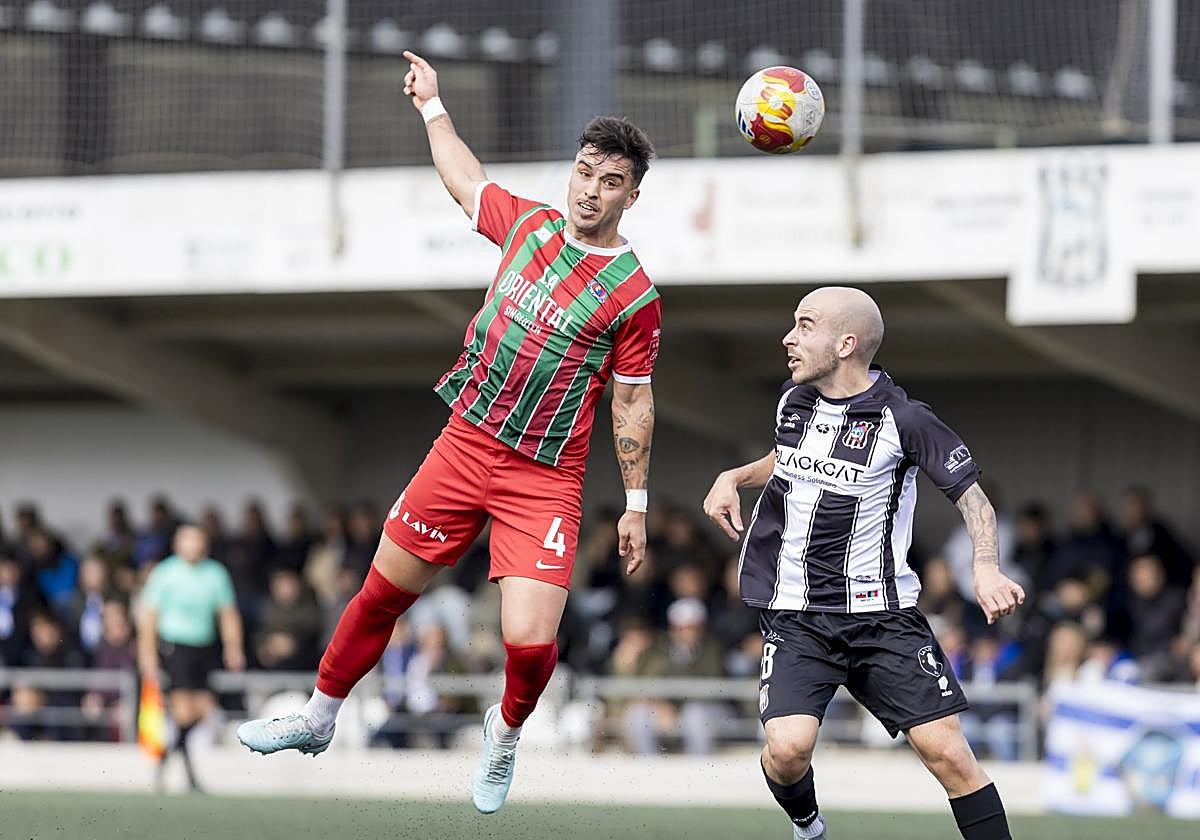 Goñi, de la Gimnástica (izquierda) cabecea el balón ante Rafita, del Escobedo.