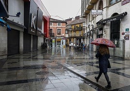 Vecinos caminan ayer por la calle Goya de Torrelavega, donde fue hallado un hombre herido este pasado domingo.