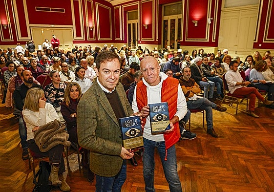 Javier Sierra y Miguel Blanco, presentador del acto, ante un salón repleto en el Casino de Barreda.