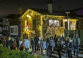 Visitantes transitan entre las casas iluminadas de Quijano en la Navidad de 2024.