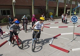 Alumnos realizan una clase de seguridad vial en el patio exterior del centro educativo.