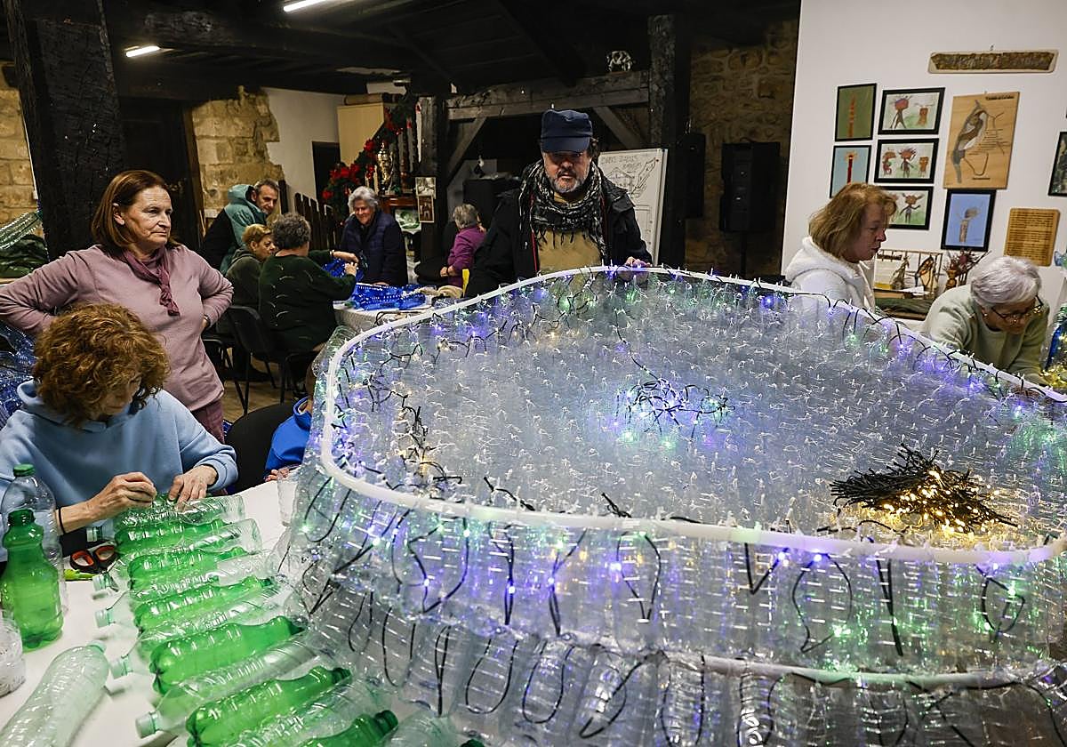 Vecinos de Barcenaciones trabajan en la creación de las figuras con botellas de plástico.