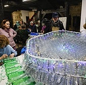 Vecinos de Barcenaciones trabajan en la creación de las figuras con botellas de plástico.