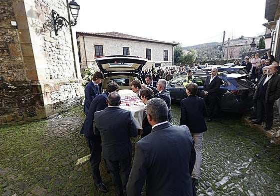 Los restos mortales del escritor son introducidos en el coche fúnebre antes de ser trasladados al cementerio.