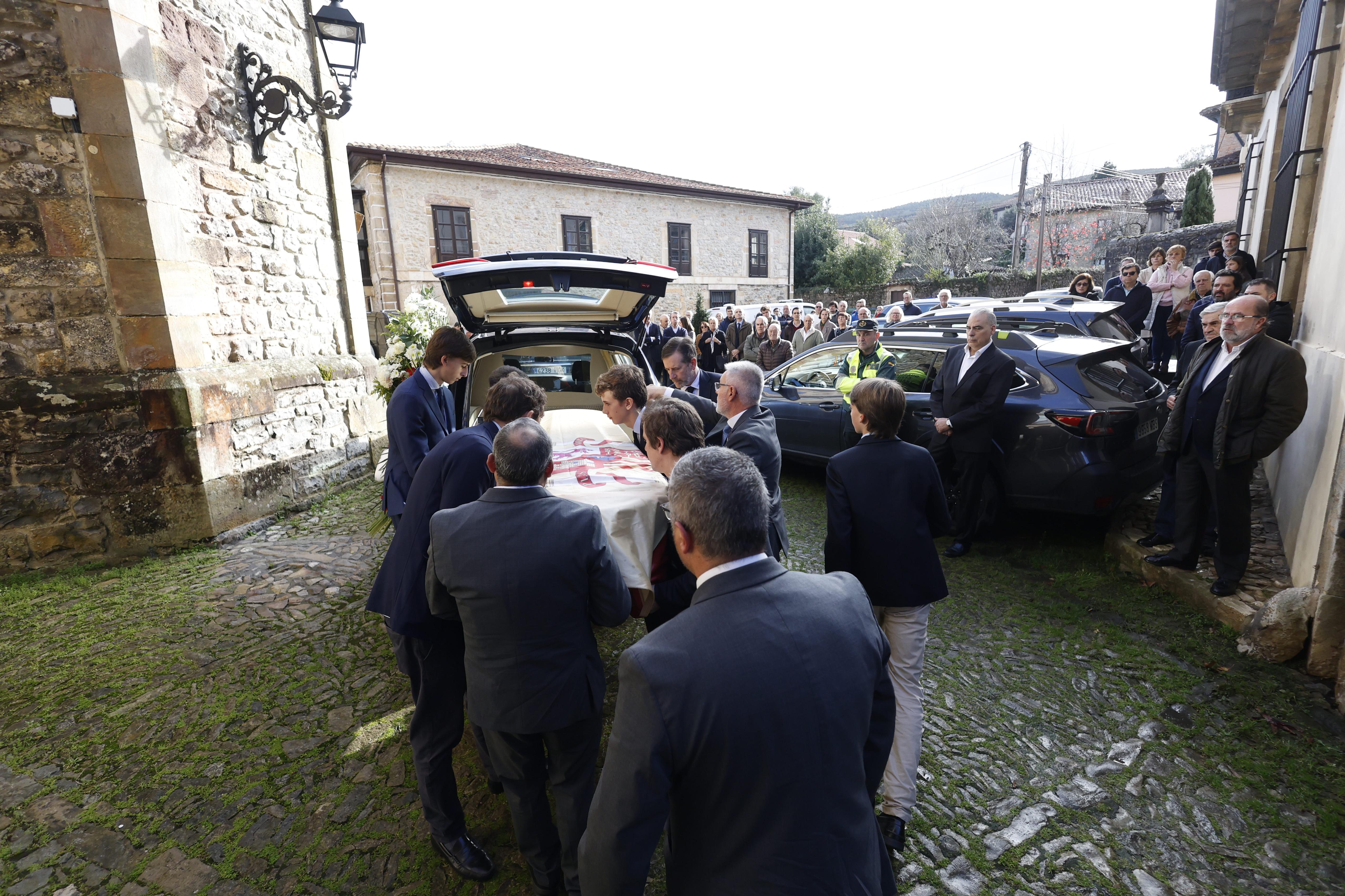 Los restos mortales del escritor son introducidos en el coche fúnebre antes de ser trasladados al cementerio.