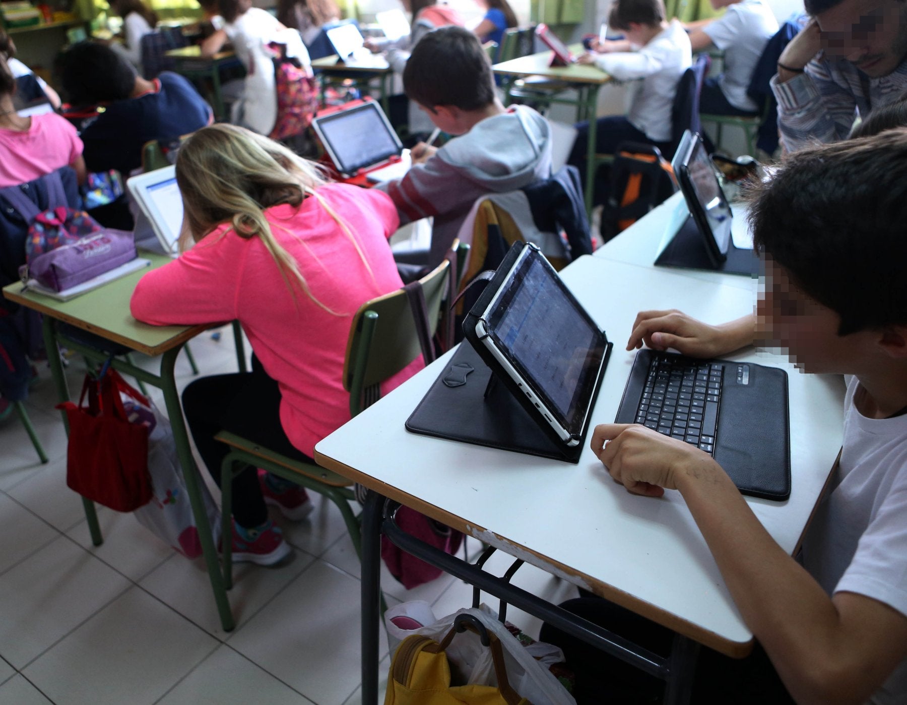 Alumnos trabajando con sus ordenadores en una clase