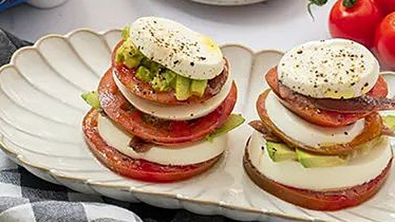 Milhojas de tomate con aguacate, anchoas y queso fresco