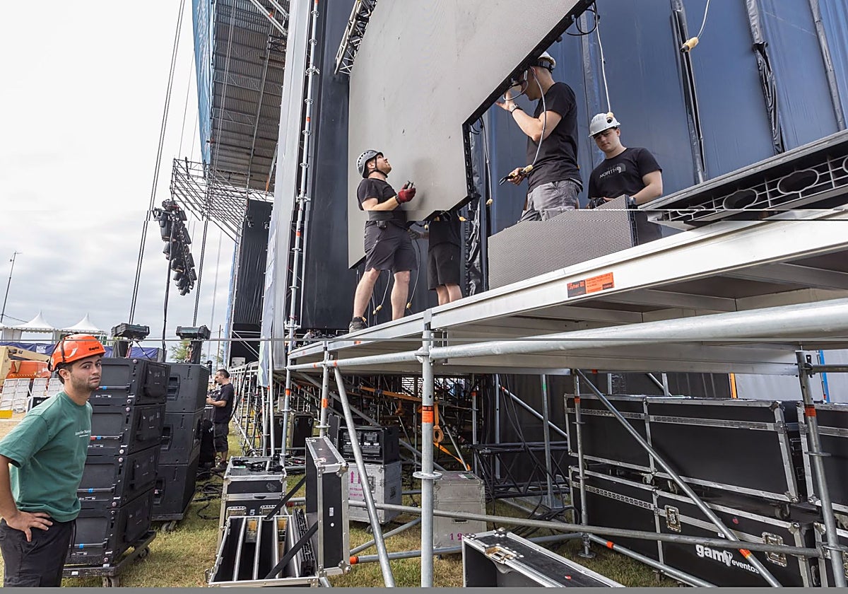 Los operarios montan las pantallas del escenario que se levanta en la Campa de La Magdalena.